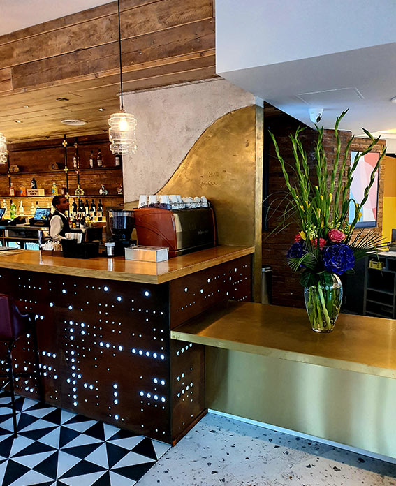Rust metal finish to bar facade and gold liquid metal finish to columns at the Maldron Hotel in London.